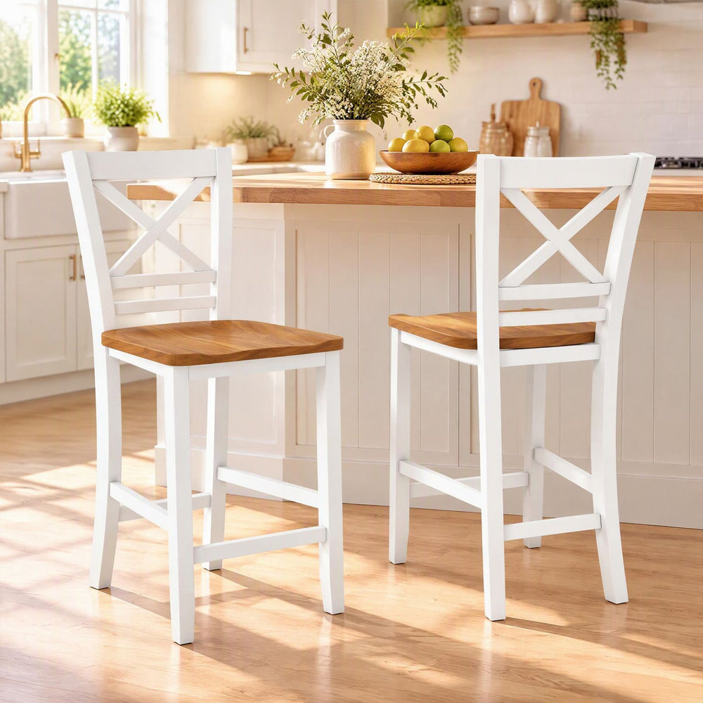 Pair of white solid wood bar stools with rubber wood frame and cross backrests beside a kitchen island.