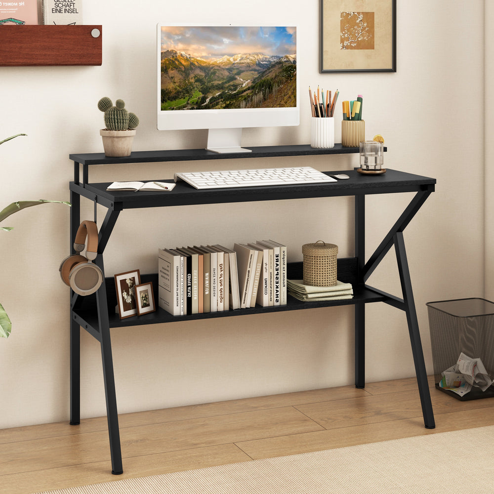 Black space-saving computer desk with monitor stand, extra storage shelf, and hanging hook for organized workspaces.