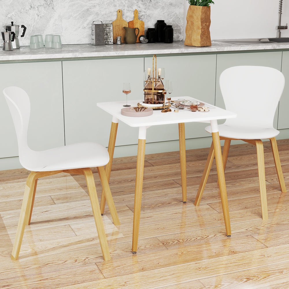 Square dining table with white surface and wooden legs, featuring adjustable foot pads for stability in small kitchens.