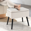Beige velvet storage ottoman with solid wood legs, featuring a hinged lid for convenient storage and a chic design.