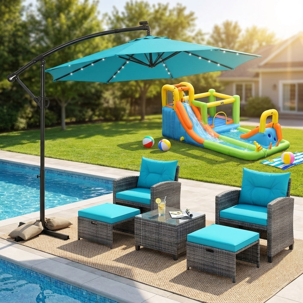 5-piece rattan furniture set with turquoise cushions and a 10ft LED offset umbrella, perfect for outdoor relaxation.