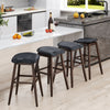 Set of four swivel bar stools with padded contoured seats, black PVC leather, and rubber wood legs for kitchen use.