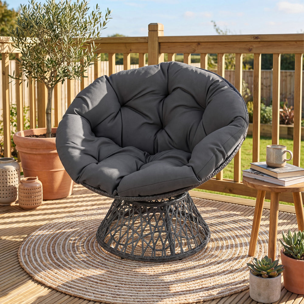 Round wicker swivel Papasan chair with thick grey cushion, perfect for outdoor relaxation on patios or in living rooms.