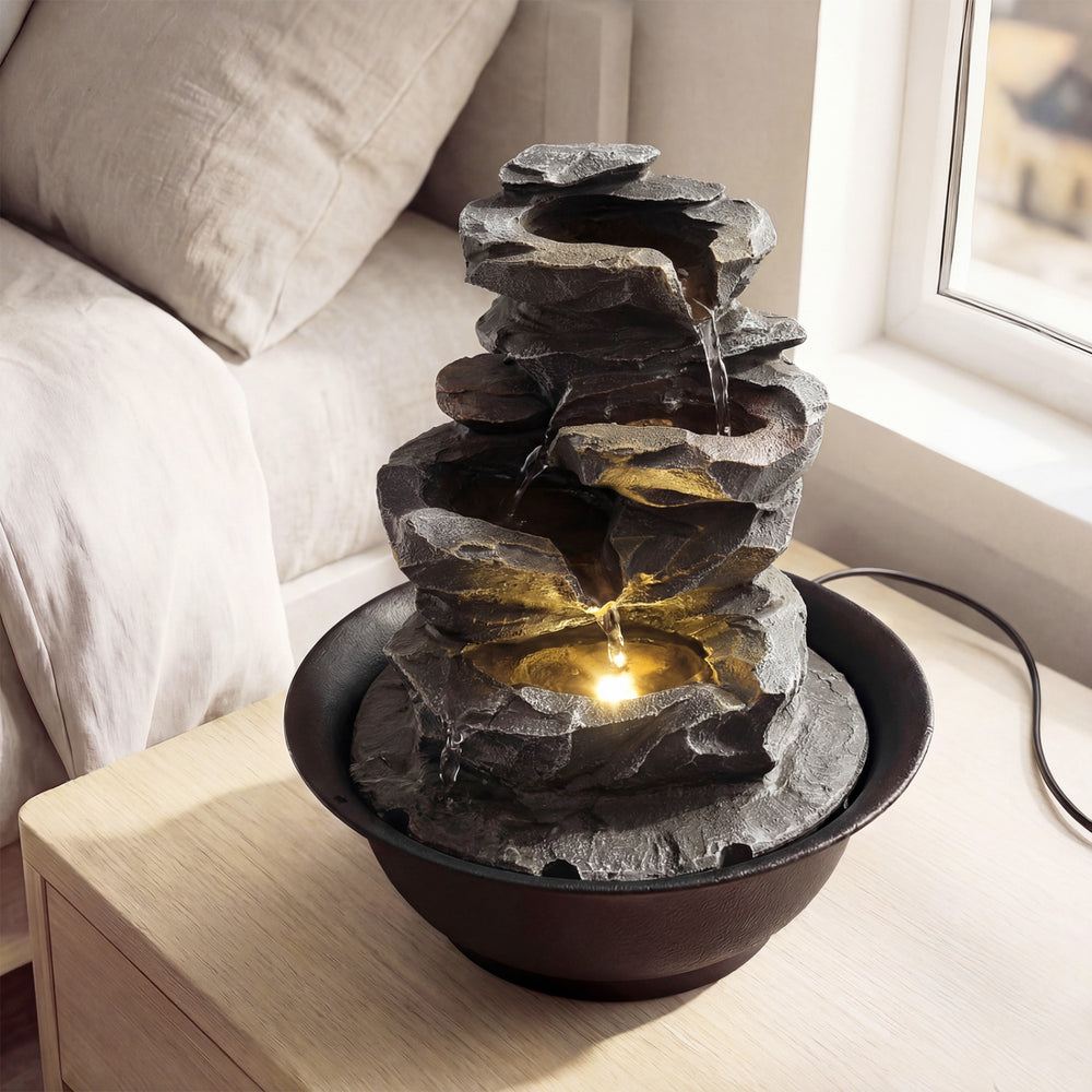 Tabletop water fountain with LED light, highlighting the gentle waterfall effect and soft glow for tranquil indoor.