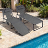 Gray tanning chairs with face and arm holes, adjustable backrest, and storage pockets for poolside relaxation.