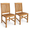 Pair of teak wood armless dining chairs with slatted seats and H-shaped footrests, shown at an angle in natural teak finish.