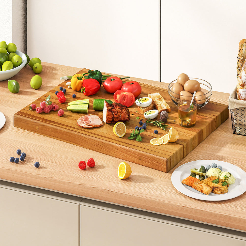 Extra large 24" teak wood cutting board with handle, featuring vibrant fresh ingredients for versatile kitchen use.