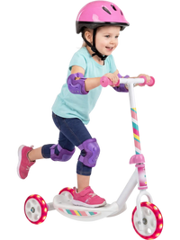 Toddler riding a pink kick scooter with LED light-up wheels and wide anti-slip deck for enhanced stability and safety.