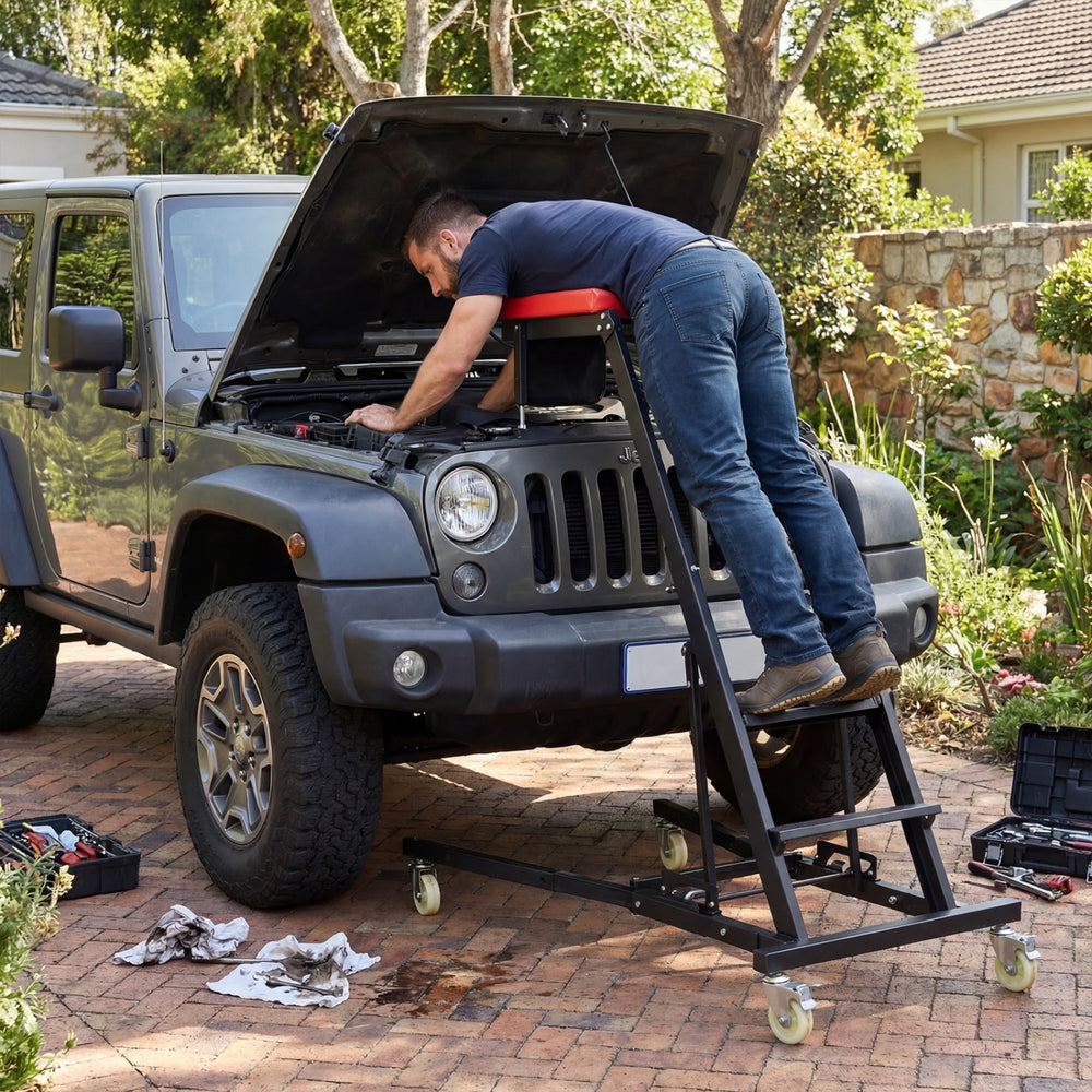 Topside automotive engine creeper in use, featuring a sturdy metal frame and adjustable height for vehicle maintenance.