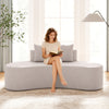 Curved gray upholstered sofa with two cozy pillows, perfect for living rooms or offices, offering comfy seating for.
