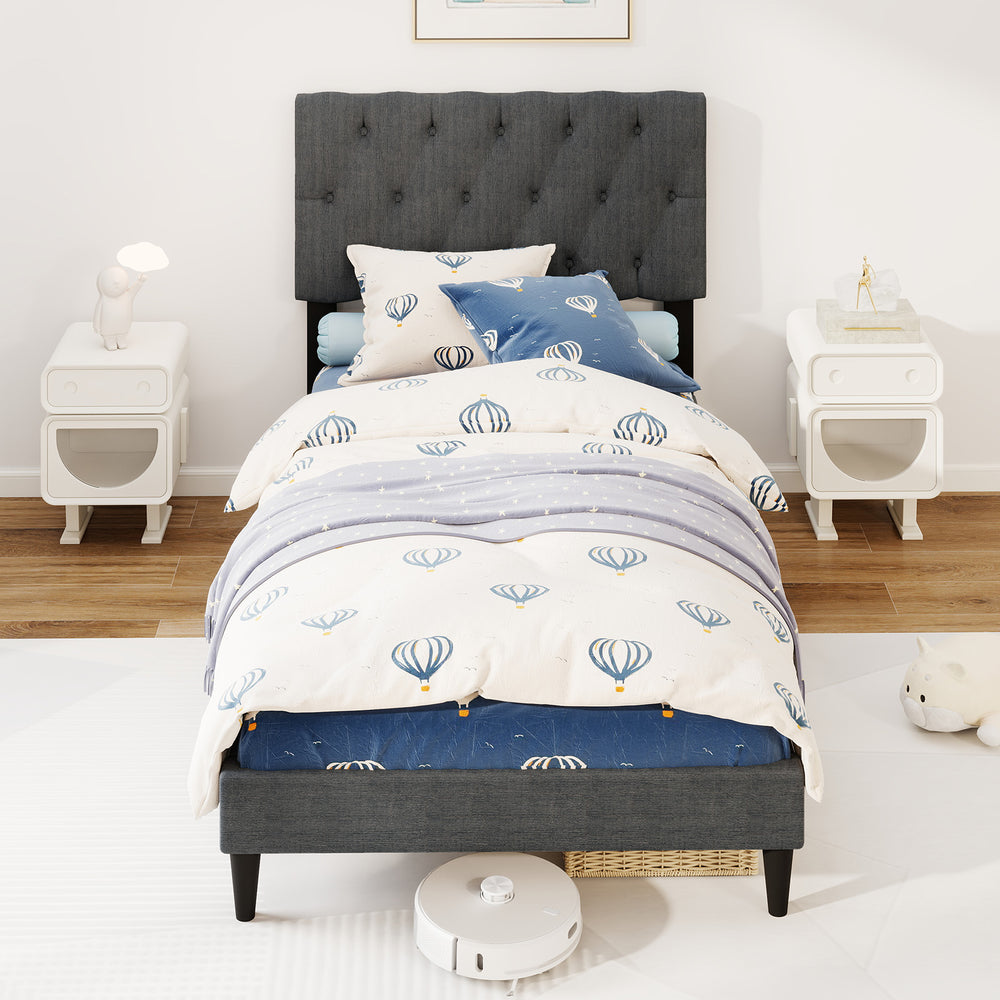 Gray twin size upholstered platform bed with tufted headboard, featuring a soft padded surface and wooden slats.