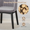 Curved backrest of grey upholstered velvet dining chair with sturdy rubber wood legs, ideal for dining and relaxation.