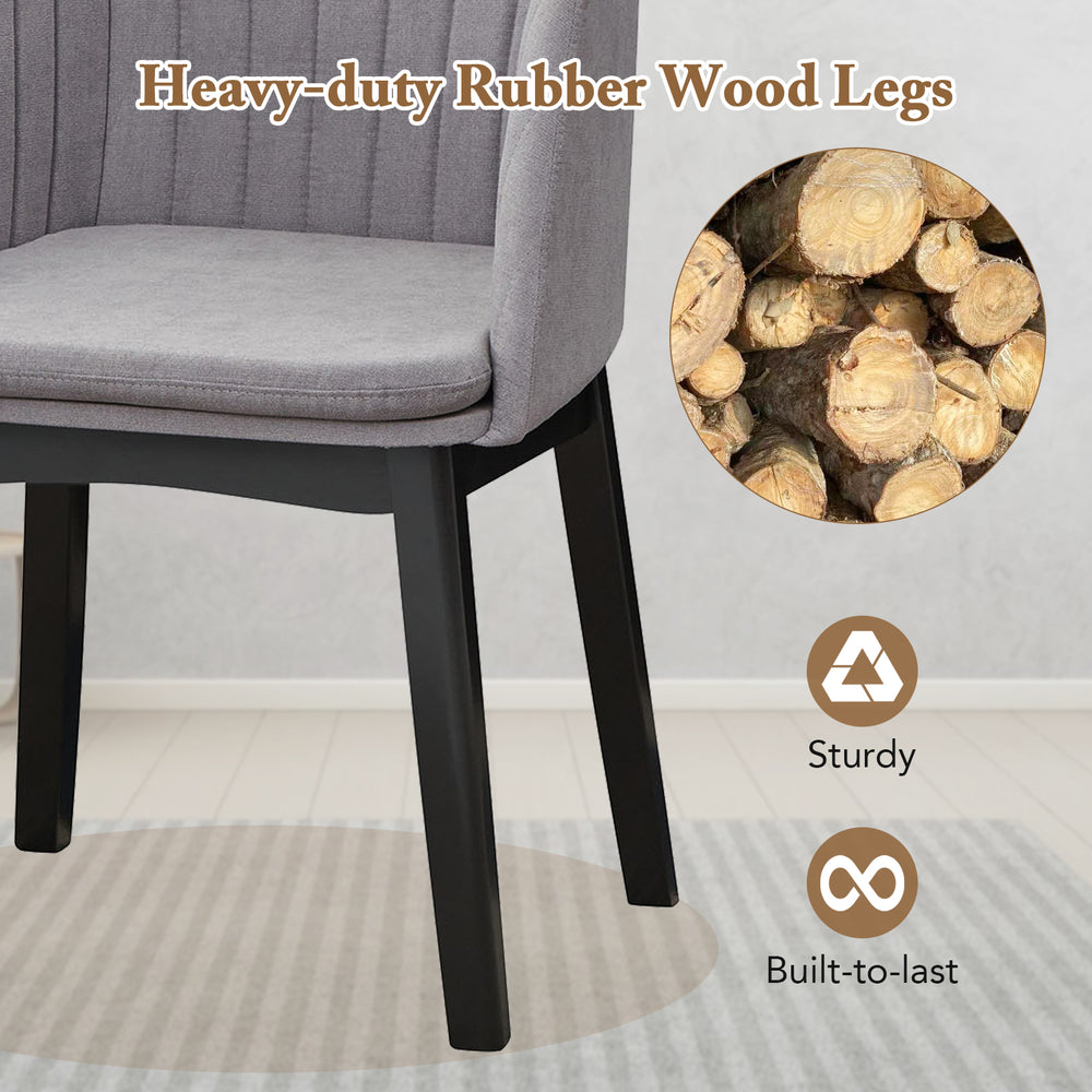 Curved backrest of grey upholstered velvet dining chair with sturdy rubber wood legs, ideal for dining and relaxation.