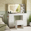 White vanity desk with lighted mirror, 3 open shelves, 7 drawers, and padded stool for makeup application.