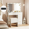 Vanity desk with lighted mirror and power outlets, featuring ample storage and a padded stool for makeup application.