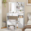Vanity desk with mirror and lights in white, featuring open shelves, large drawer, and cushioned storage stool for.