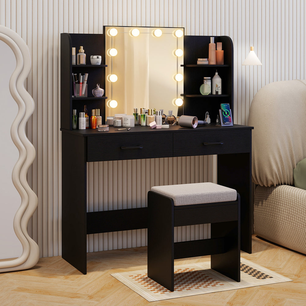 Black vanity set featuring a lighted mirror, cushioned stool, and ample storage with drawers and shelves for makeup.