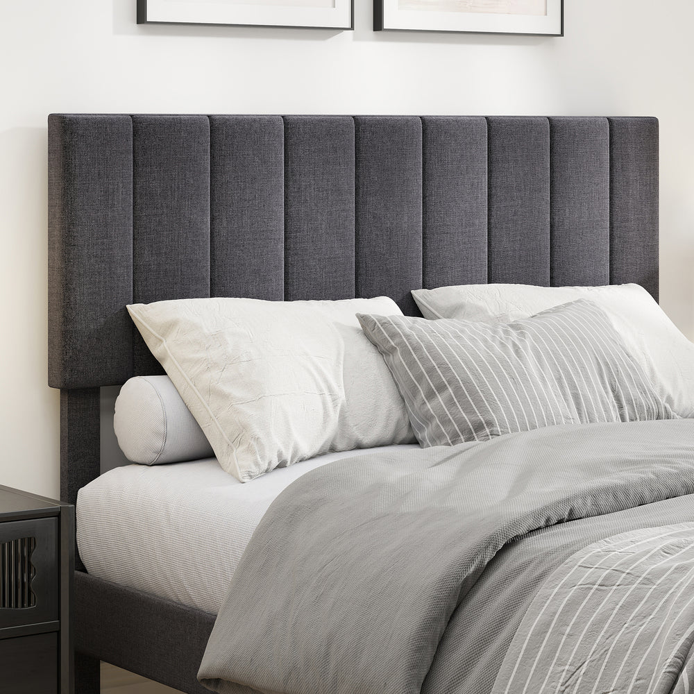 Full view of the velvet upholstered platform bed with height adjustable vertical channel headboard and gray bedding.