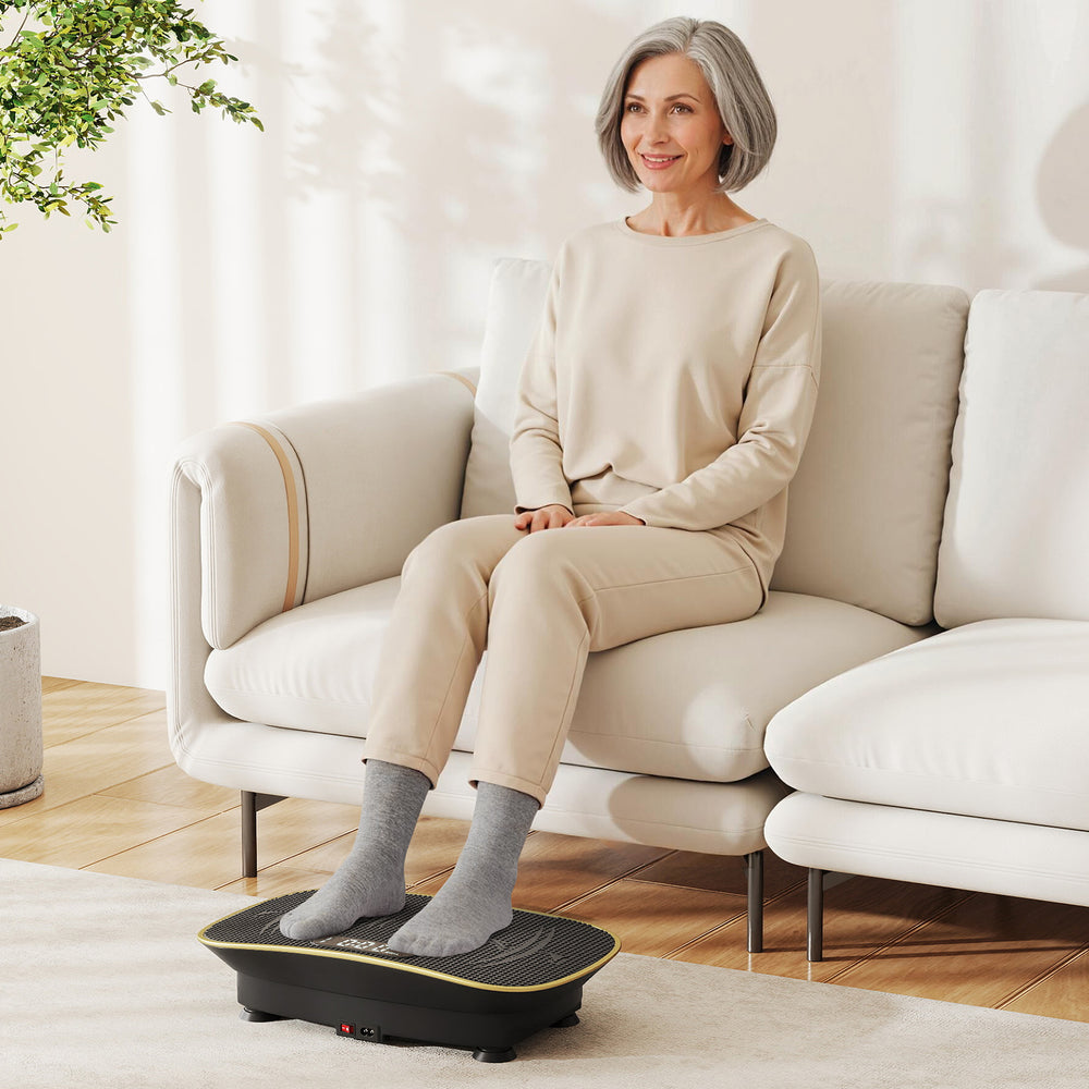 Vibration plate exercise machine in black, featuring a user on it, designed for lymphatic drainage and weight loss.