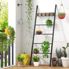Wall-leaning decorative blanket holder with 5 removable hooks, featuring a durable black metal frame for stylish.
