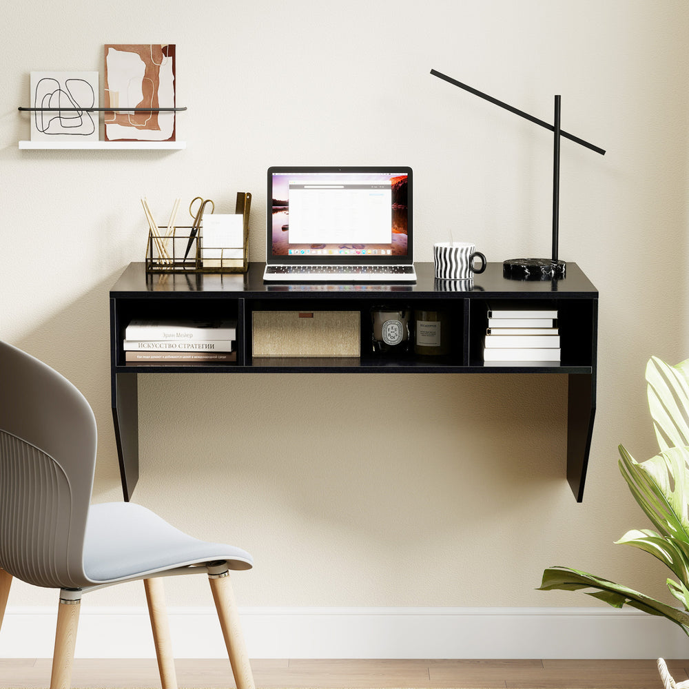 Wall-mounted black computer desk with 3 storage compartments, featuring a spacious surface for laptops and monitors.