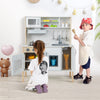 Wooden pretend play kitchen set for toddlers in white with accessories, promoting creativity and hands-on skills.