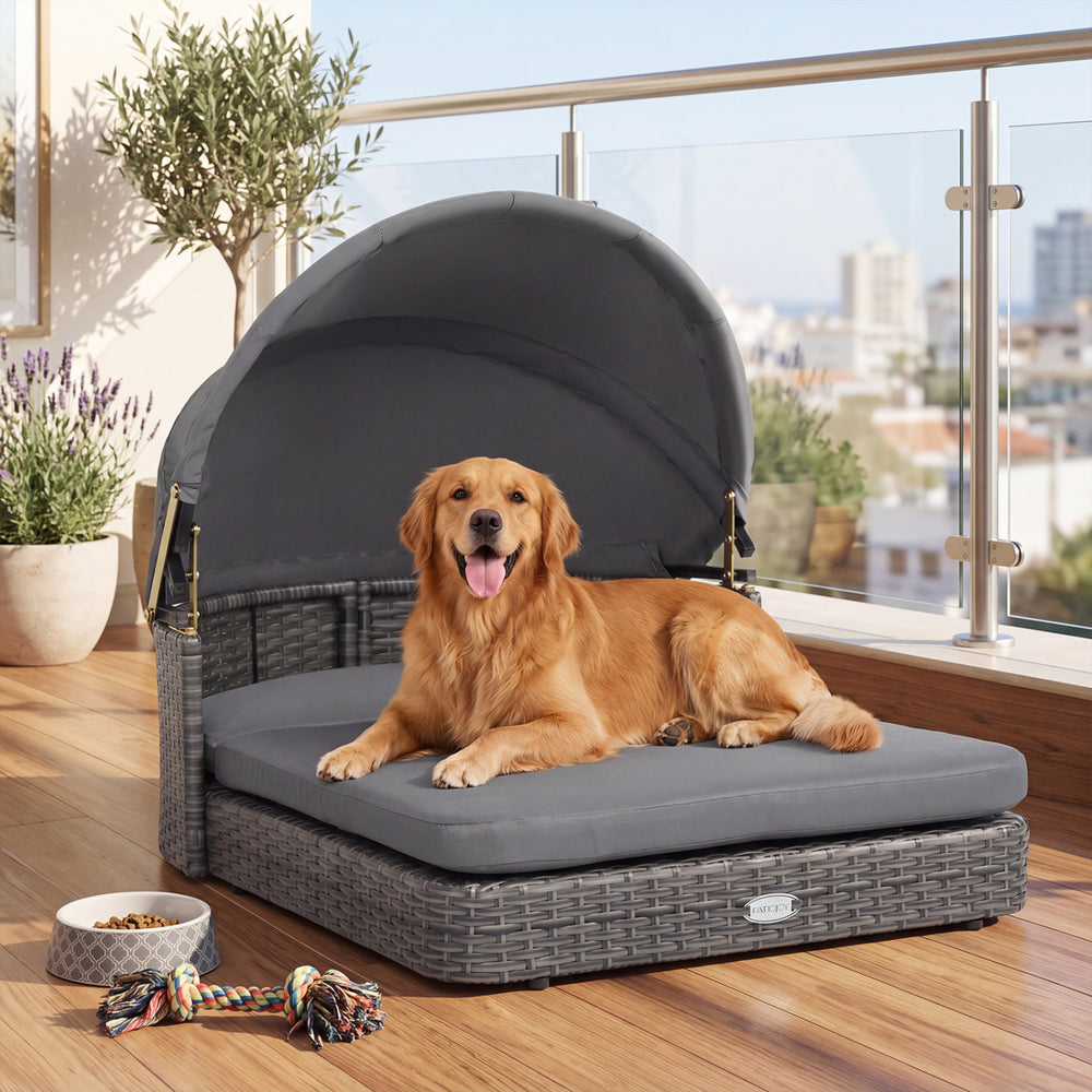 Wicker dog house with adjustable canopy and gray cushions, designed for small to medium dogs, perfect for outdoor lounging.