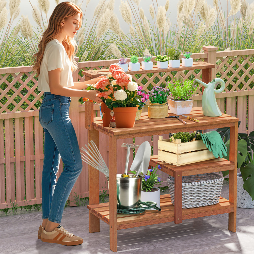 Wooden outdoor garden potting workstation with open shelves, perfect for plant care on patio or backyard.