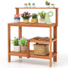 Wooden outdoor garden potting workstation with open shelves, featuring plants and tools, ideal for patios and backyards.