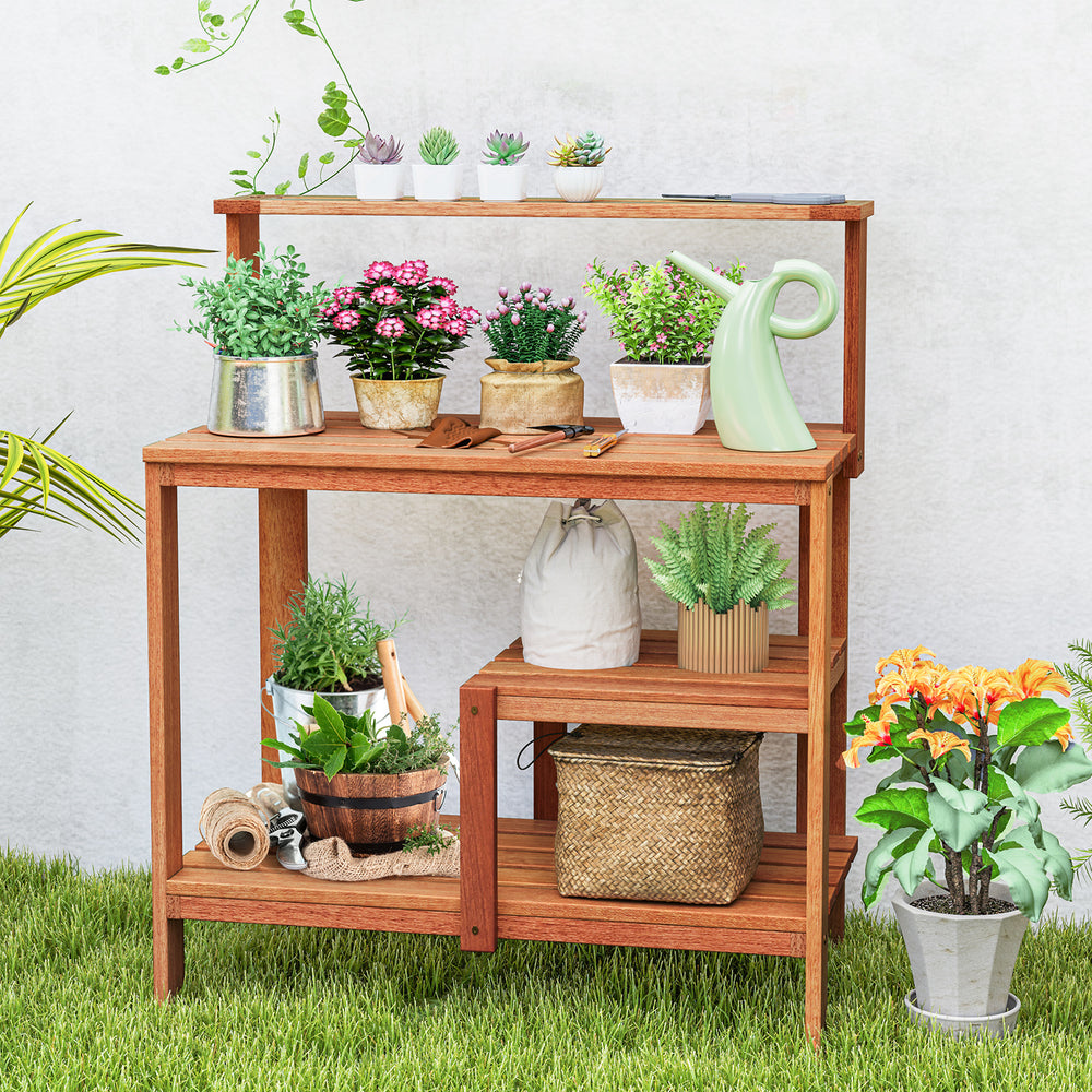Outdoor garden potting workstation made of solid wood with open shelves, ideal for plant care on patio or backyard.