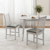 Two white wooden dining chairs with padded seats, crafted from rubber wood, ideal for dining rooms or cafes.