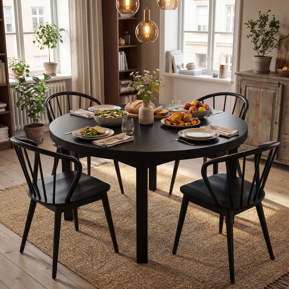 Black wooden dining chair set of 2 with high spindle backs, placed around a round dining table in a cozy setting.