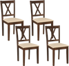 Four armless dining chairs with padded seats and rubber wood legs, designed for space-saving in dining rooms or.