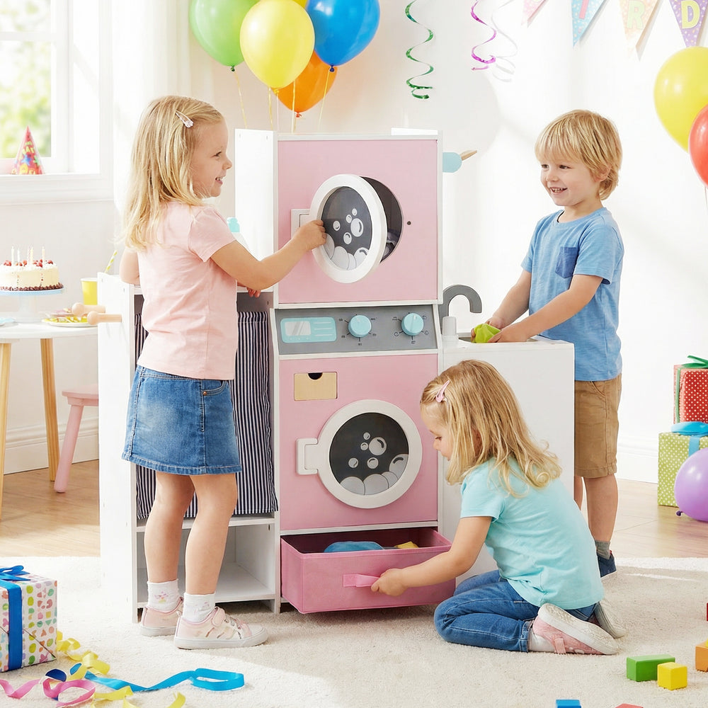 Wooden kids laundry playset in pink with washing machines, detergent bottle, and clothes hangers for imaginative play.