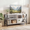 White wooden TV stand with X-shaped frame and large tabletop, providing open storage for books and audiovisual equipment.