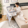 Baby bassinet bedside crib in gray with adjustable height, mesh sides, and comfy mattress for easy access to baby.