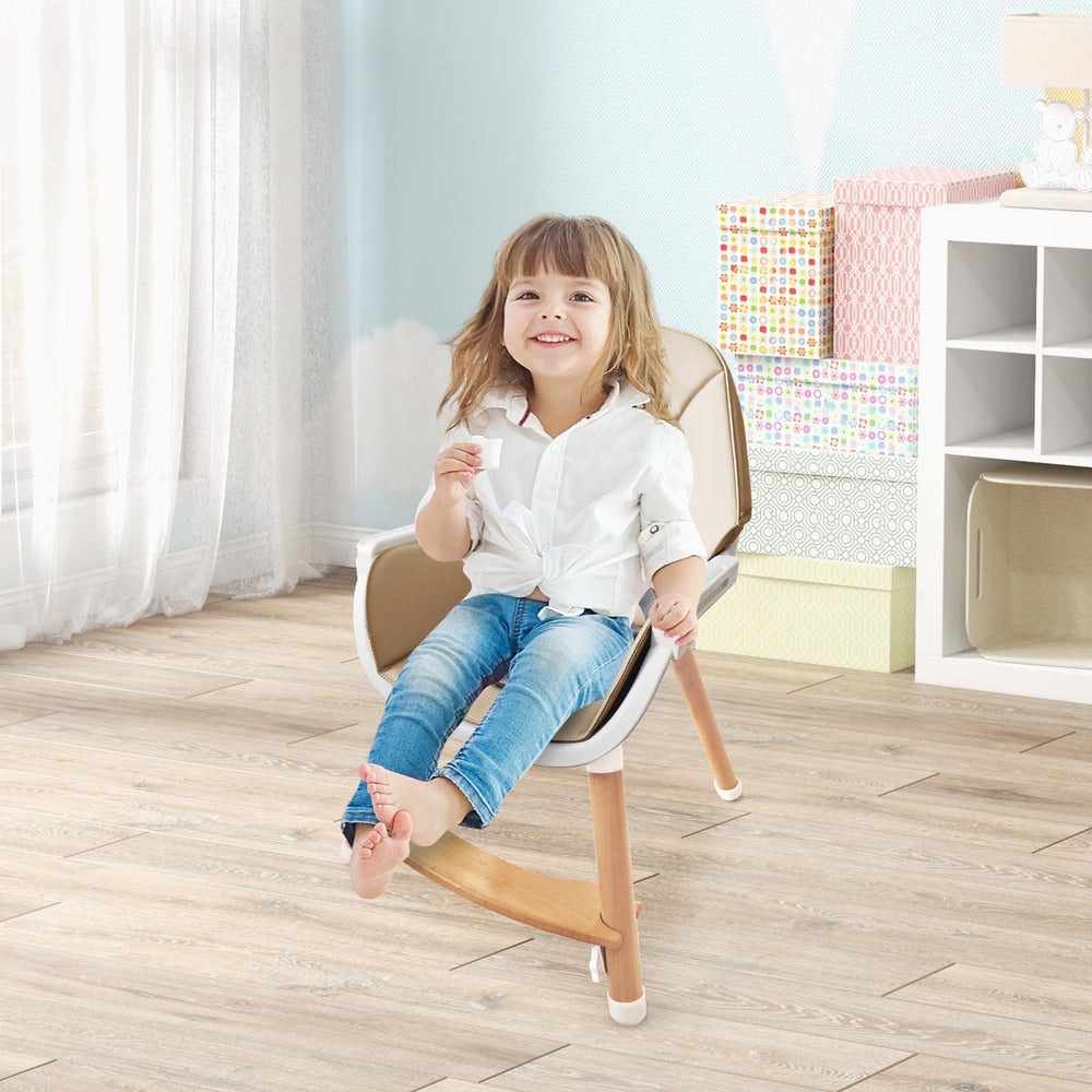 Child sitting in a beige baby high chair with solid beech wood legs, featuring a dishwasher-safe tray and 5-point.