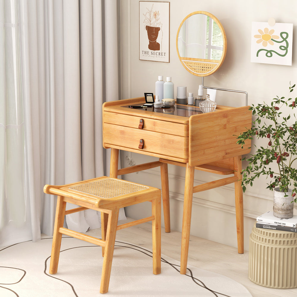 Bamboo makeup vanity table with rotating mirror and stool, featuring two drawers and a tempered glass top for organized.