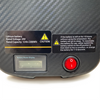 Air Elite Max Battery pack with warning labels and power button on a carbon fiber surface