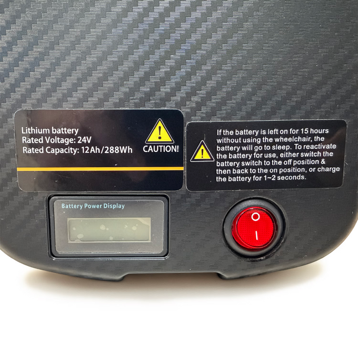 Air Elite Max Battery pack with warning labels and power button on a carbon fiber surface