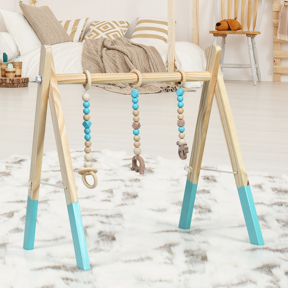 Wooden newborn baby activity gym with blue accents and hanging teething toys, perfect for exercise and mental.