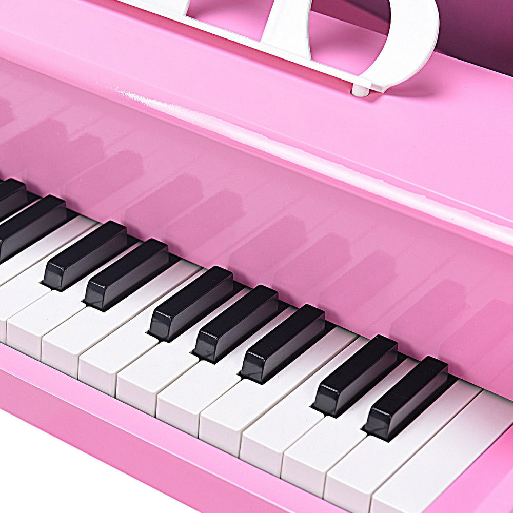 Close-up of the pink 30-key mini grand piano, featuring black and white keys, ideal for children aged 1 to 7.