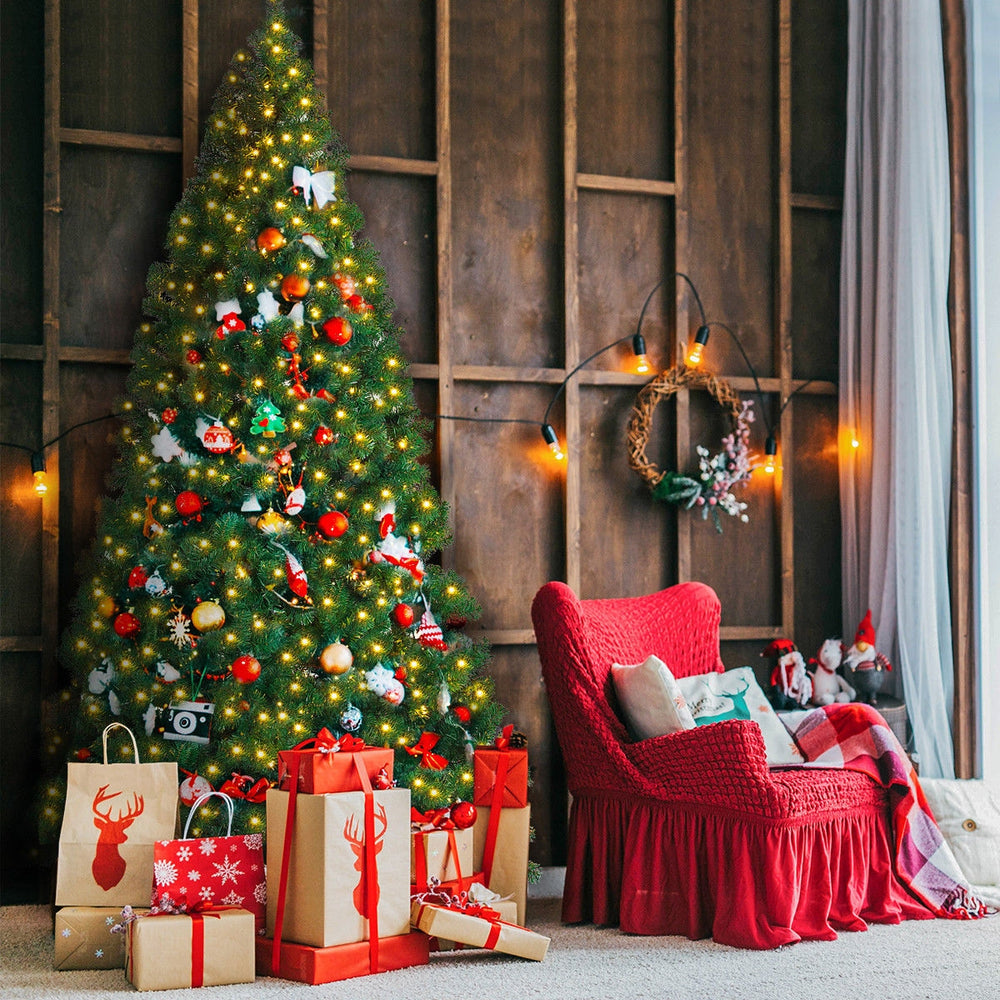 9-foot pre-lit PVC artificial Christmas tree with 700 LED lights, surrounded by festive decorations and gifts for.