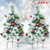 Set of 2 pre-lit 2 feet Christmas trees with snow flocked leaves, red ornaments, and warm LED lights for festive decor.