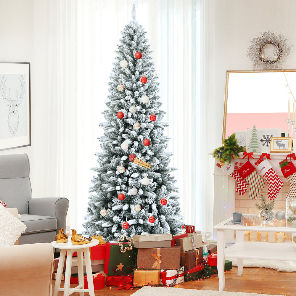 Snow-flocked 7.5 ft artificial Christmas pencil tree with mixed tips, decorated and surrounded by festive gifts.
