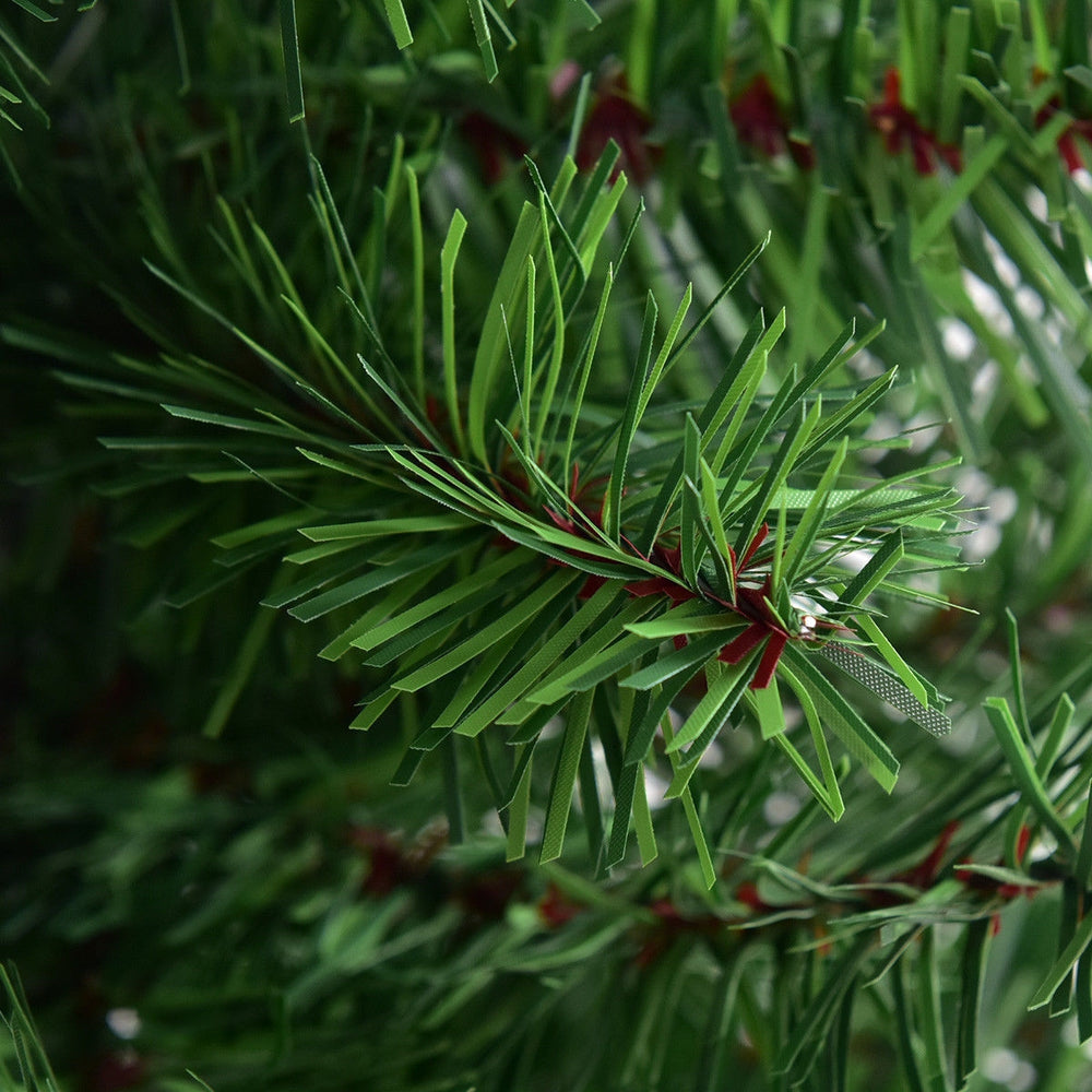 Close-up of green PVC branches of a 2 ft artificial Christmas tree with a burlap bag base for stability.