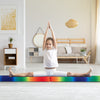 Child performing a split on a multicolor folding balance beam with solid wood base, ideal for home training or.