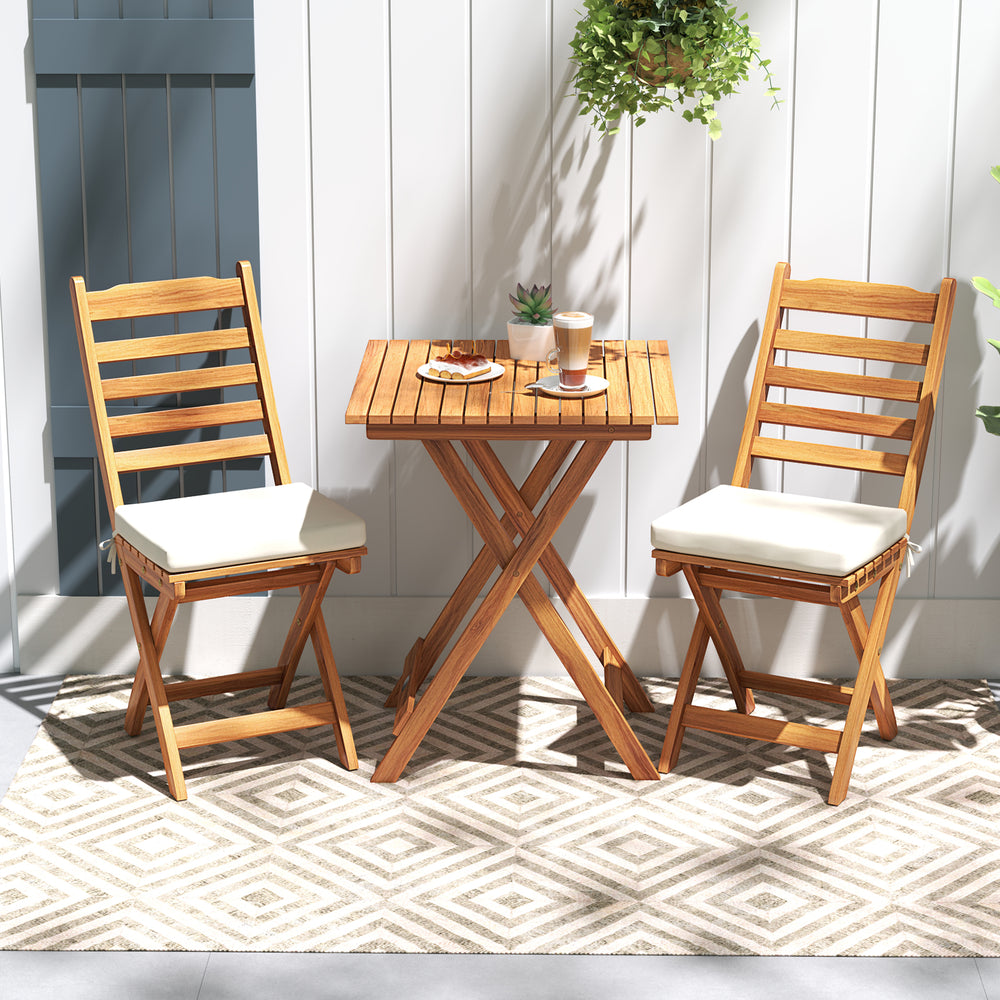 Folding chair table set in natural acacia wood with soft seat cushions, ideal for backyard or balcony relaxation.