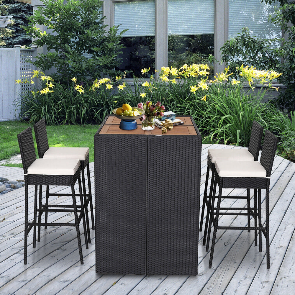 5-piece patio dining set featuring a solid acacia wood table and weather-resistant PE wicker bar stools with cushions.