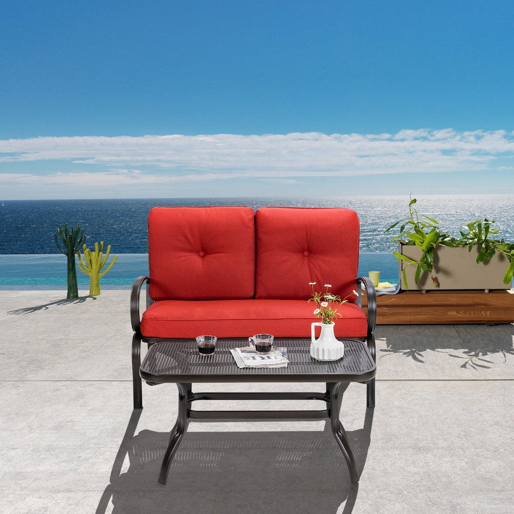 Loveseat with red cushions and coffee table, made of durable steel, ideal for outdoor patio and garden relaxation.